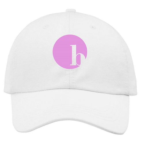 The BirdieBall Hat (White Logo) by BirdieBall is a white and pink dad hat featuring a pink circle with a lowercase white "h" on the front and an adjustable back strap for comfort.