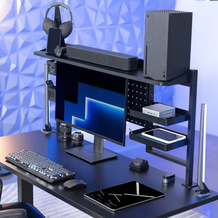 Gaming desk setup with computer monitor, keyboard, mouse, and gaming accessories on a blue geometric background.