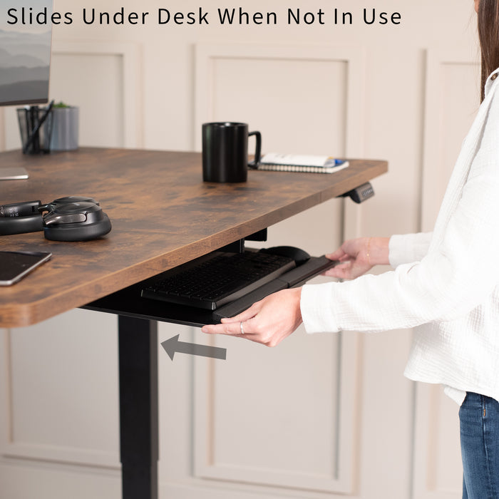 Person using a desk with a keyboard tray under the surface
