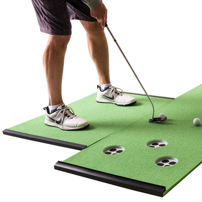 A person stands on a BirdieBall Golf Stance Mat (options available), preparing to putt a golf ball toward one of several holes in the artificial turf.