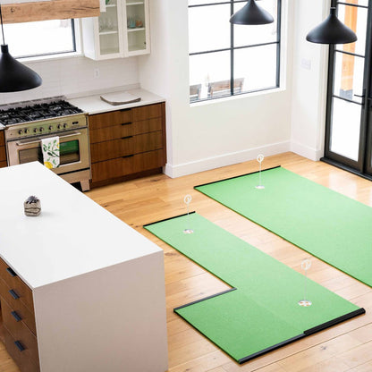 A modern kitchen with a white island and wooden cabinets features two BirdieBall Golf Stance Mats (various options) on the wood floor, each with golf hole markers for perfecting your stance and aim.
