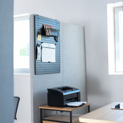 Printers on a wooden desk with a pegboard wall in an office setting