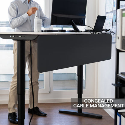 A black laminate modesty panel attached to a desk in an office with concealed cable management.