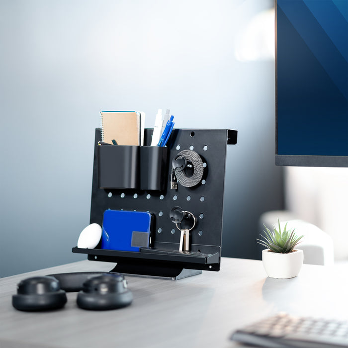 A black pegboard desk organizer with various slots and holders for office supplies and a mobile phone.