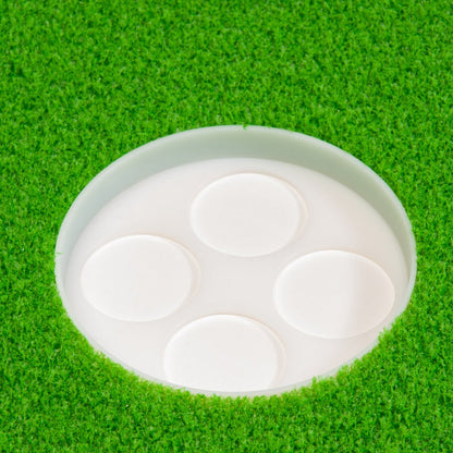 The BirdieBall Putting Green Cups and Flags (Options Available) come with four white flat circular markers, set in artificial green turf—an ideal accessory to enhance your putting green setup.