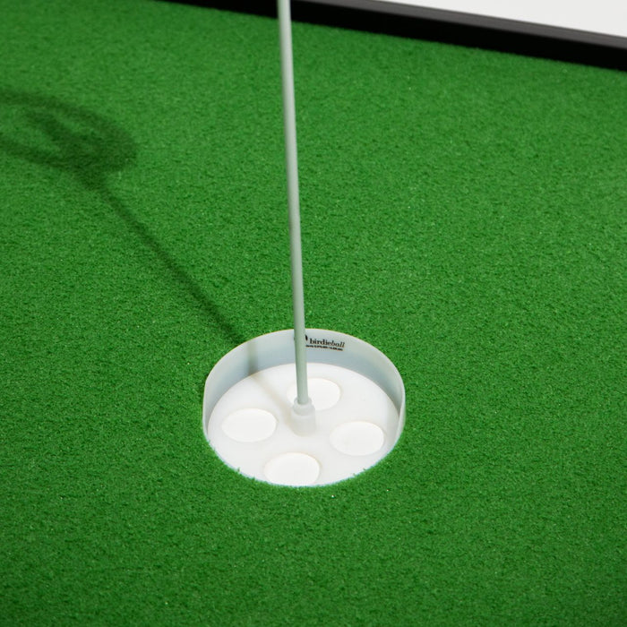 Close-up of a golf hole on artificial green turf with BirdieBall Putting Green Cups and Flags (options available) installed in the center.