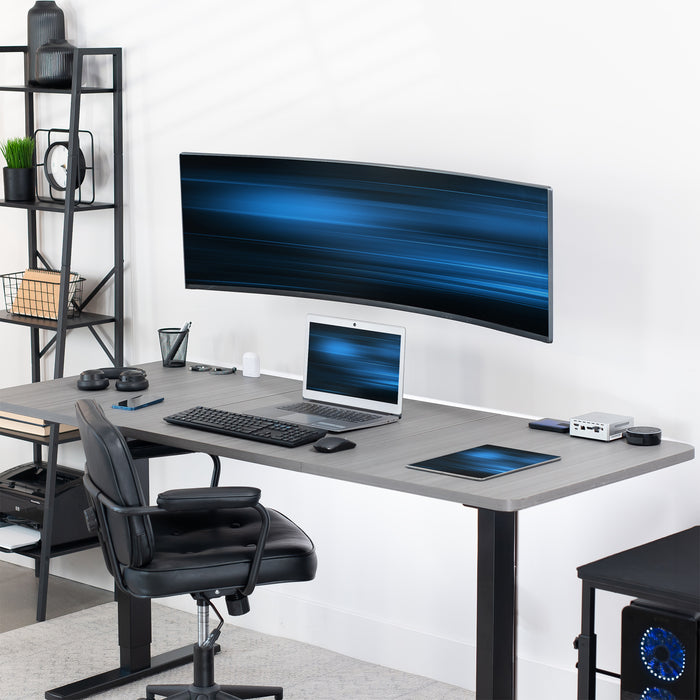 Ultrawide monitor wall mount holding a large curved screen above a desk for a space-saving workstation